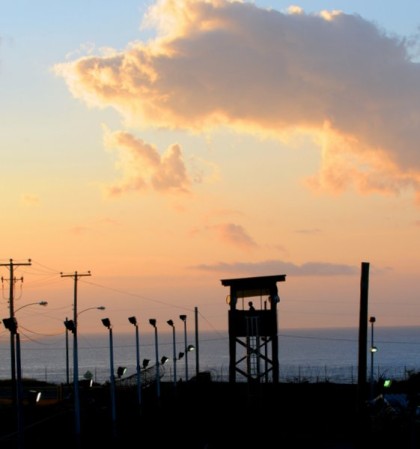 GUANTANAMO BAY, Cuba – Spc. Emely Nieves from the Puerto Rico Army National Guard guards her post over the Joint Task Force Guantanamo detention facility at sunrise, Jan. 7. JTF Guantanamo provides safe, humane, legal and transparent care and custody of detainees, including those convicted by military commission and those ordered released by a court. The JTF conducts intelligence collection, analysis and dissemination for the protection of detainees and personnel working in JTF Guantanamo facilities and in support of the War on Terror. JTF Guantanamo provides support to the Office of Military Commissions, to law enforcement and to war crimes investigations. The JTF conducts planning for and, on order, responds to Caribbean mass migration operations. (JTF Guantanamo photo by U.S. Air Force Senior Airman Gino Reyes) UNCLASSIFIED – Cleared for public release. For additional information contact JTF Guantanamo PAO 011-5399-3589; DSN 660-3589 www.jtfgtmo.southcom.mil
